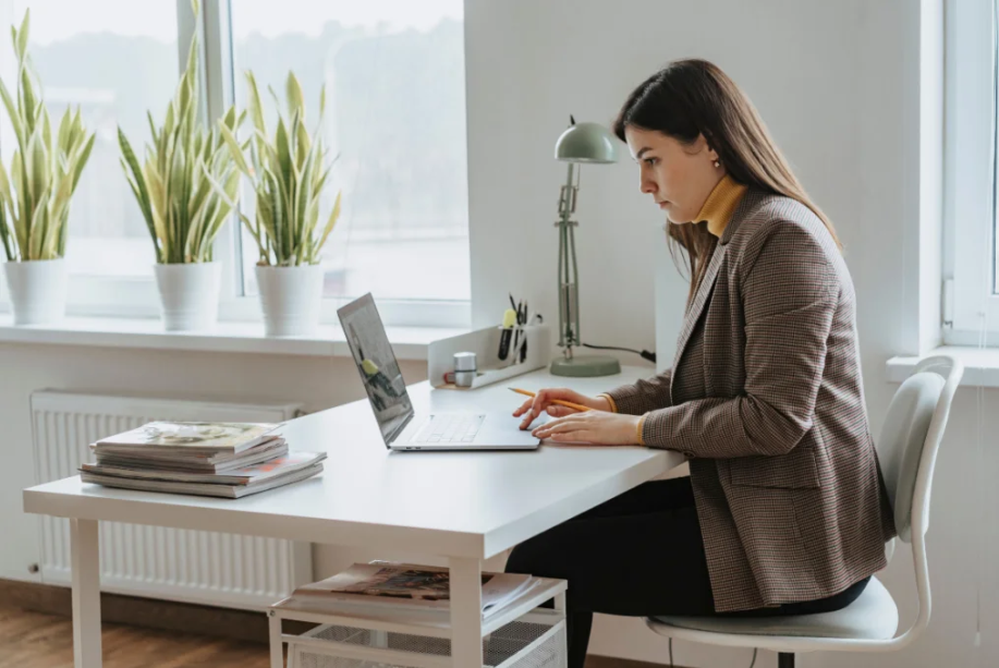 Image of a woman sitting at a desk working on a laptop