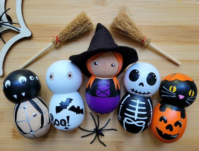 Image of Halloween themed peg dolls, shapes include: witch. ghost, pumpkin, spider, skeleton.