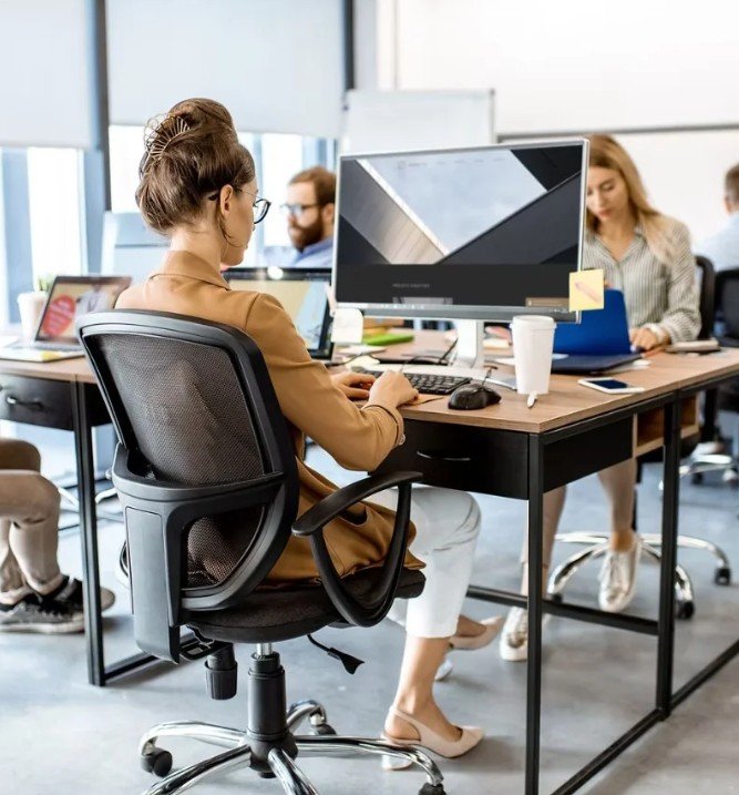 Image of a woman sitting at a desk - wellness in the workplace